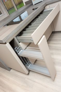 an open drawer in the middle of a kitchen