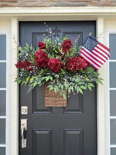 a basket with flowers and an american flag hanging on the front door