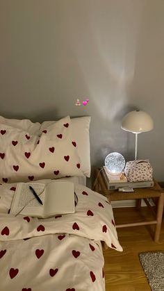 a laptop computer sitting on top of a bed next to a lamp and pillow case