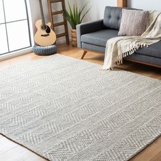 a living room with a gray couch and white rug