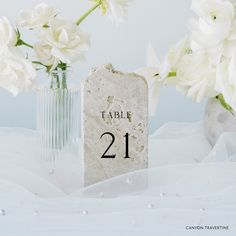 a table number sitting next to some white flowers