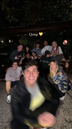 a group of people sitting on the ground posing for a photo with one person smiling