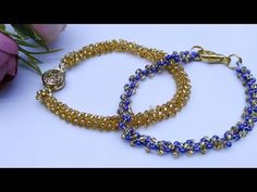 two bracelets with blue and gold beads are sitting next to a rose on a table