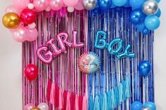 balloons and streamers with the word girl on them are hanging in front of a wall