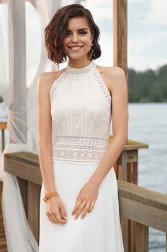 a woman in a white dress standing on a dock