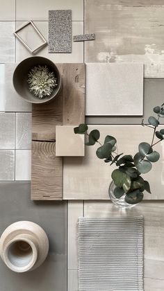 a vase filled with flowers sitting on top of a table next to tiles and a potted plant