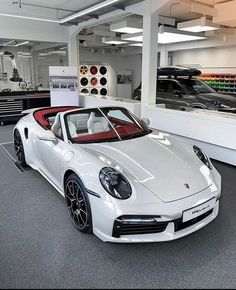 a white sports car parked in a showroom