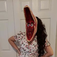 a woman wearing a fake mouth mask standing in front of a door