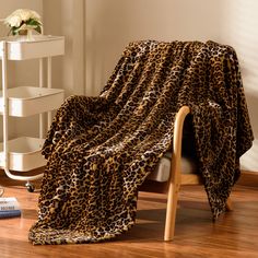 a leopard print blanket sitting on top of a wooden chair