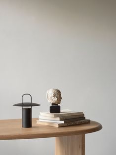 a table topped with books and a white busturine sitting on top of it