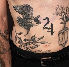 a man with tattoos on his stomach has an eagle and flowers tattoo on his chest