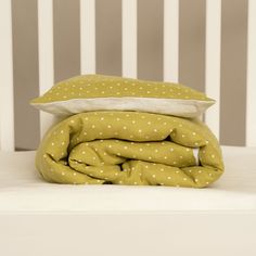 a stack of pillows sitting on top of a bed