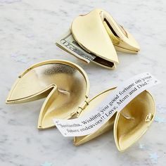 three gold money clips sitting on top of a white marble counter next to each other