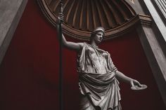 a statue in front of a red wall