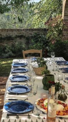 the table is set with blue plates and place settings