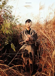 a man standing in the middle of tall grass