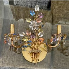 a gold wall light with multicolored crystals on it