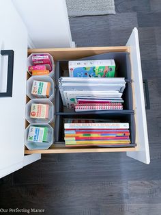 an organized drawer with books and magazines in it