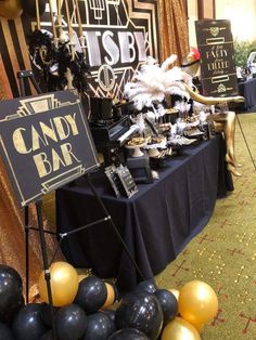 black and gold party decorations at a candy bar with balloons in the foregrounds