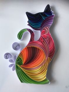 a colorful paper cut out of an abstract cat with swirly tail and tail ends