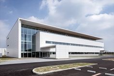 an empty parking lot in front of a large white building