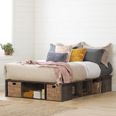 a bed with storage drawers underneath it in a white room next to a wooden floor