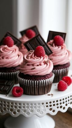 chocolate cupcakes with raspberry frosting on a cake stand