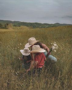 two people kneeling in the middle of a field