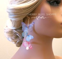 a mannequin head with earrings on it and a hair piece in the shape of a butterfly