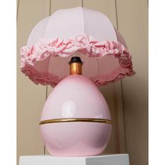 a pink lamp sitting on top of a white box