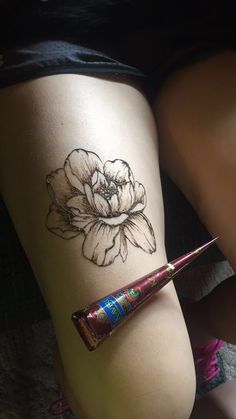 a woman's thigh with a flower tattoo on it and a candy bar in the foreground