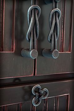 an old wooden door with metal handles and chains hanging on it's front doors