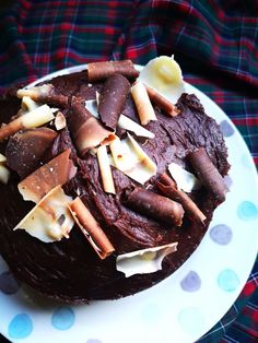 a chocolate cake with white frosting and toppings on a polka dot platter