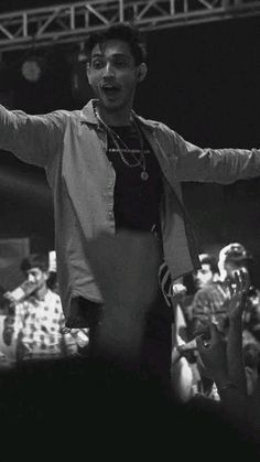 a man standing in front of a crowd holding his arms out