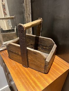 an old wooden crate sitting on top of a table next to a mirror and window