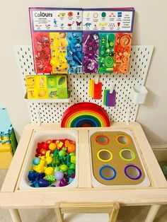 a child's play table with two trays filled with colorful beads and toys