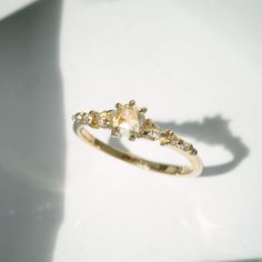 a yellow gold ring with two diamonds on it's sides and a shadow behind it