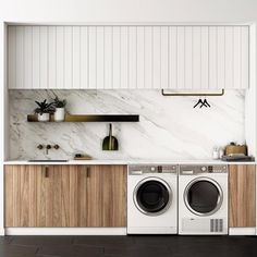 a washer and dryer in a kitchen with marble counter tops on the wall