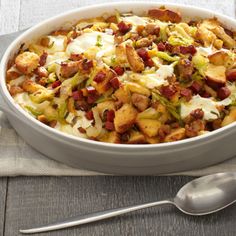 a casserole dish with meat and vegetables in it on a napkin next to a spoon