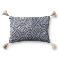 a blue and white pillow with tassels