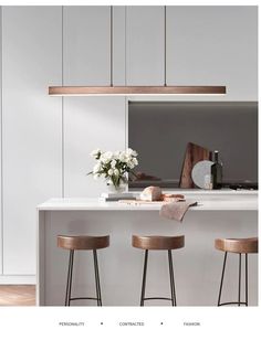 three stools are sitting at the bar in this modern kitchen with white walls and wood flooring