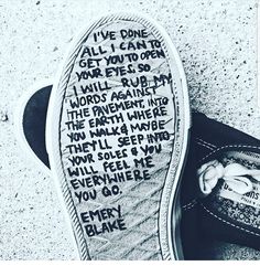 black and white photograph of someone's shoes with words written on the soles