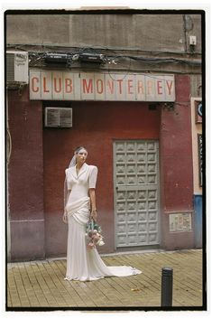 a woman standing in front of a building with a sign above her head that says club montgomery