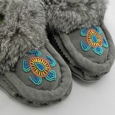 a pair of gray slippers with colorful beads on them