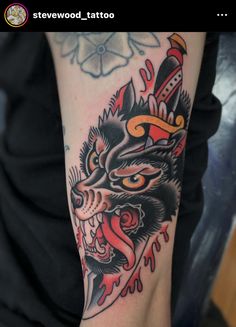 a tattoo with an image of a wolf on it's arm