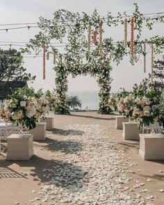 an outdoor ceremony setup with white flowers and greenery