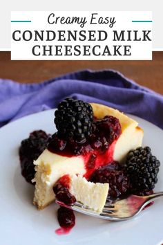 a white plate topped with cheesecake covered in berries and blackberries next to a fork