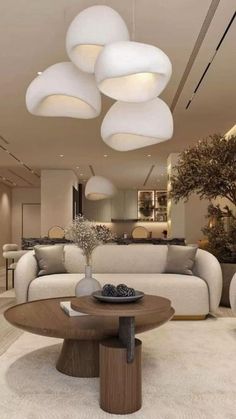 a living room filled with white furniture and lots of lights hanging above the couches