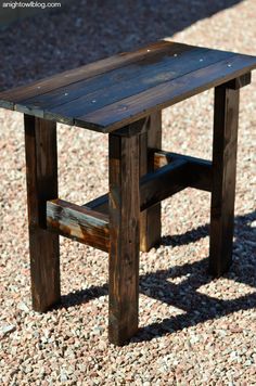 a small wooden table sitting on top of gravel