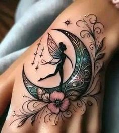 a woman's hand with a tattoo on it and a fairy sitting on the moon